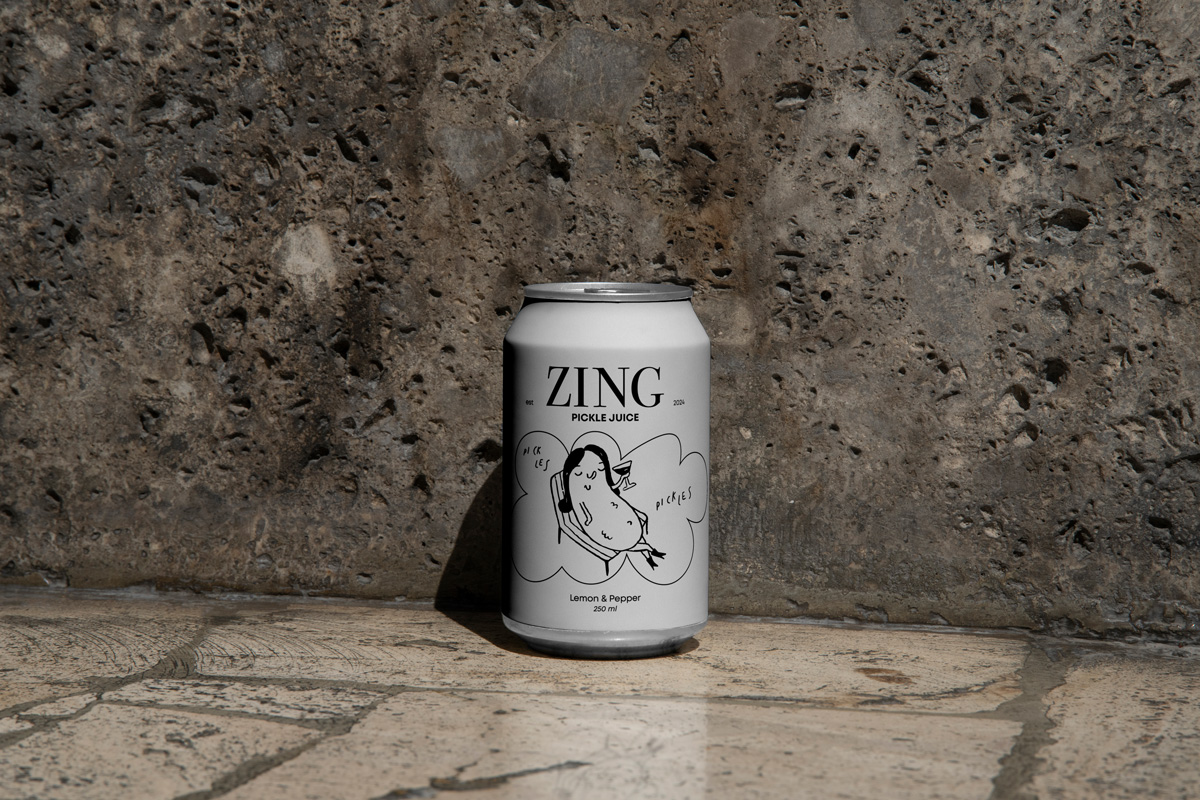 A white canned drink featuring a playful sunbathing pickle. 